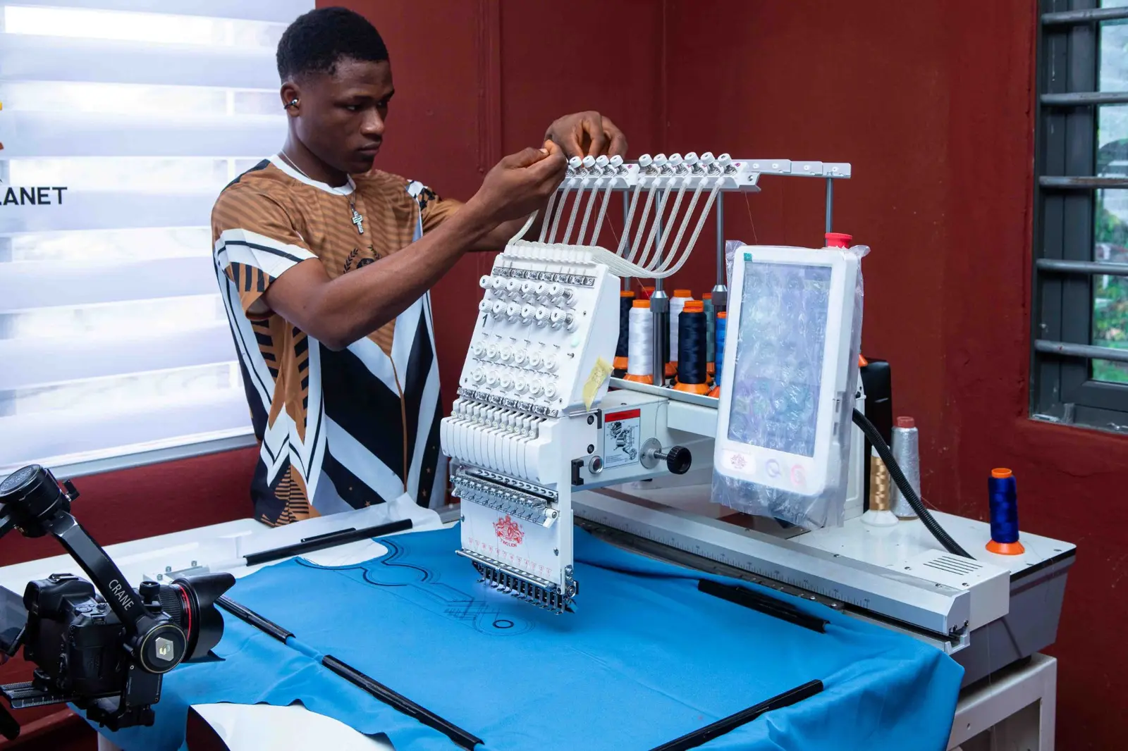 A digital embroidery head being threaded for a run on the Klot Planet Plus floor in Aba