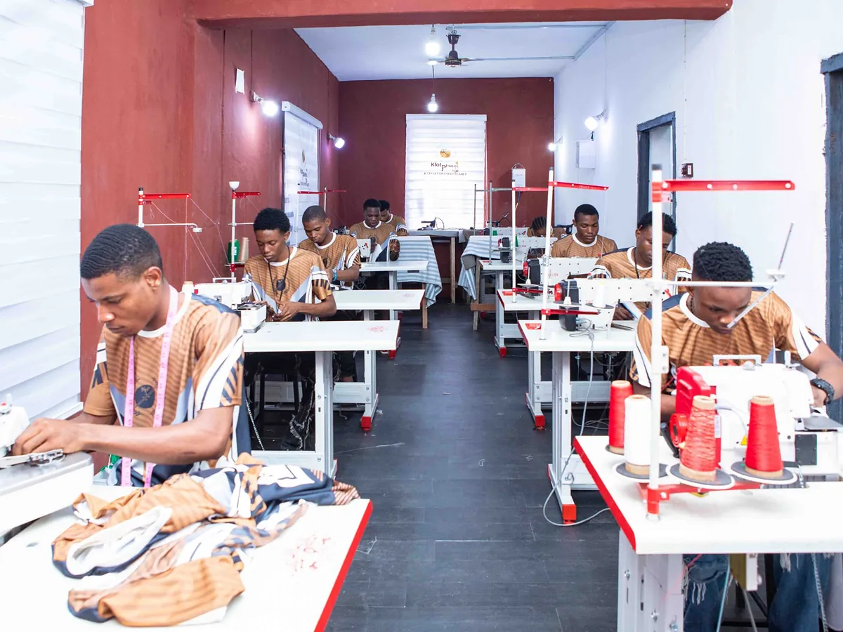 Machinists working down the sewing line, thread cones stacked beside them